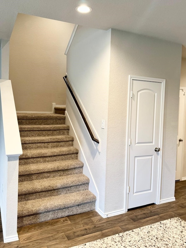staircase with recessed lighting, baseboards, and wood finished floors