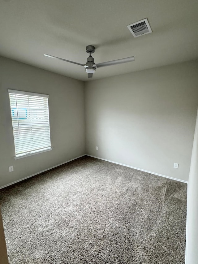 spare room featuring baseboards, visible vents, carpet, and a ceiling fan