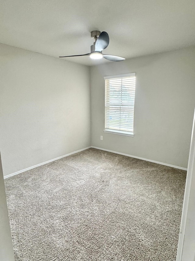 empty room featuring baseboards, carpet, and a ceiling fan