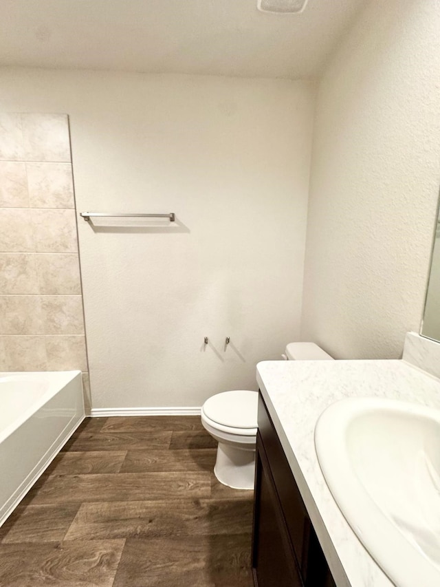full bath with baseboards, wood finished floors, toilet, and vanity