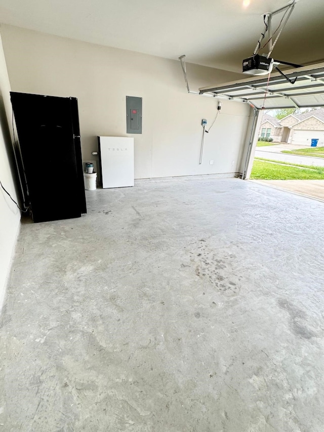 garage with freestanding refrigerator, electric panel, and a garage door opener