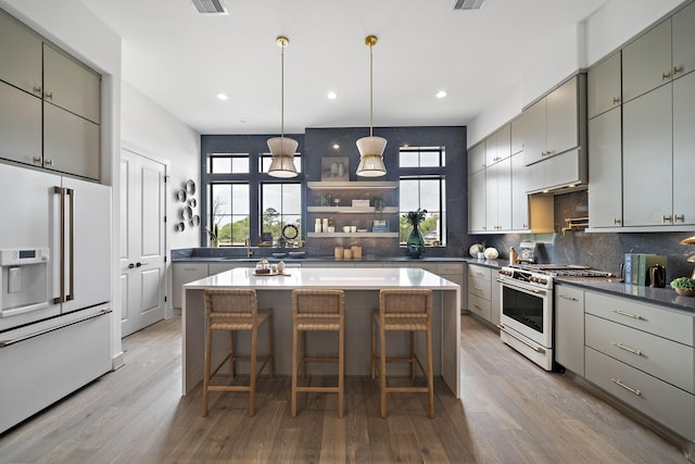 kitchen featuring decorative backsplash, gray cabinetry, a wealth of natural light, and high end appliances