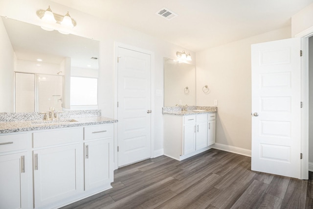 4334 W Bayou Maison Cir, Dickinson, TX 77539 - full bathroom featuring wood finished floors, two vanities, and a stall shower