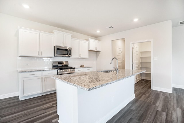 4334 W Bayou Maison Cir, Dickinson, TX 77539 - kitchen with appliances with stainless steel finishes, dark wood finished floors, white cabinetry, light stone countertops, and recessed lighting