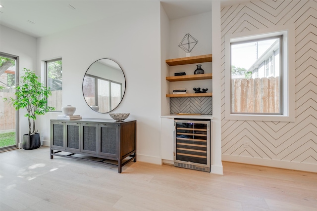 2113 Huldy St, Houston, TX 77019 - detailed view of beverage cooler, wood finished floors, baseboards, a bar, and an accent wall