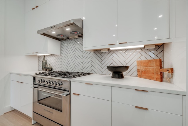 2113 Huldy St, Houston, TX 77019 - kitchen featuring stainless steel stove, range hood, modern cabinets, white cabinetry, and light countertops