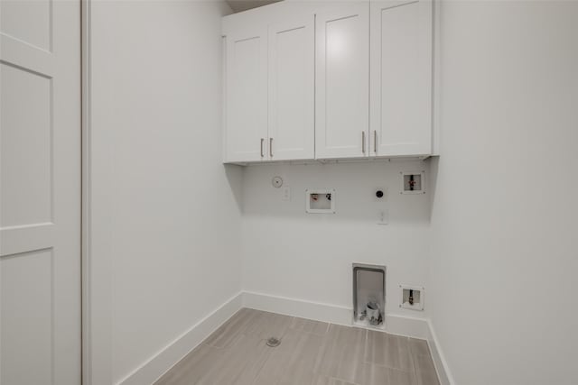 2113 Huldy St, Houston, TX 77019 - laundry room featuring hookup for a gas dryer, baseboards, washer hookup, hookup for an electric dryer, and cabinet space