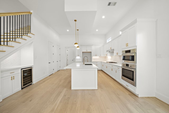 811 W 18th St, Houston, TX 77008 - kitchen with wine cooler, appliances with stainless steel finishes, backsplash, recessed lighting, and light wood-style flooring
