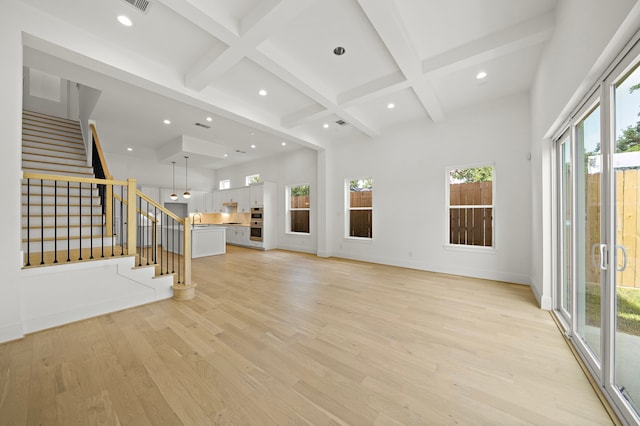 811 W 18th St, Houston, TX 77008 - unfurnished living room featuring plenty of natural light, light wood-style flooring, beamed ceiling, stairway, and recessed lighting