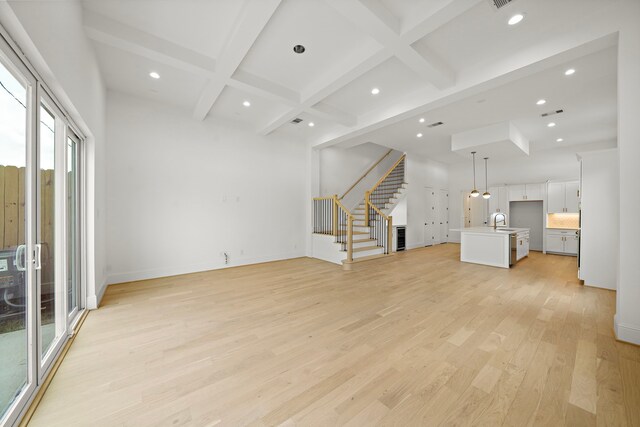 811 W 18th St, Houston, TX 77008 - unfurnished living room with light wood finished floors, stairs, recessed lighting, beam ceiling, and coffered ceiling