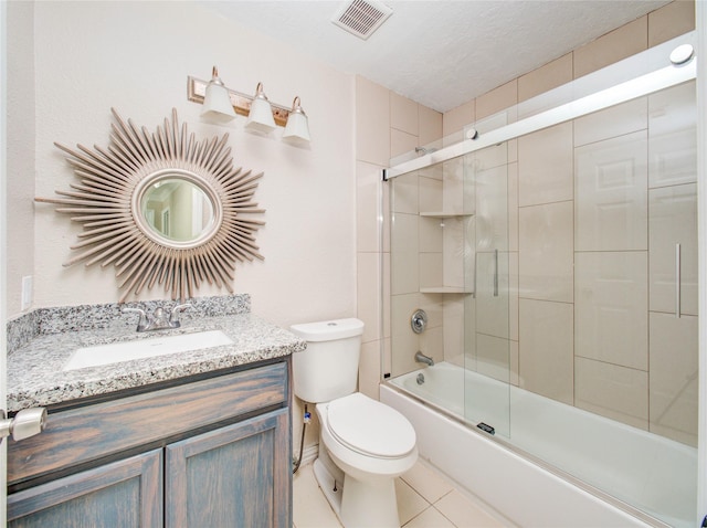 full bathroom with tile patterned floors, combined bath / shower with glass door, visible vents, toilet, and vanity