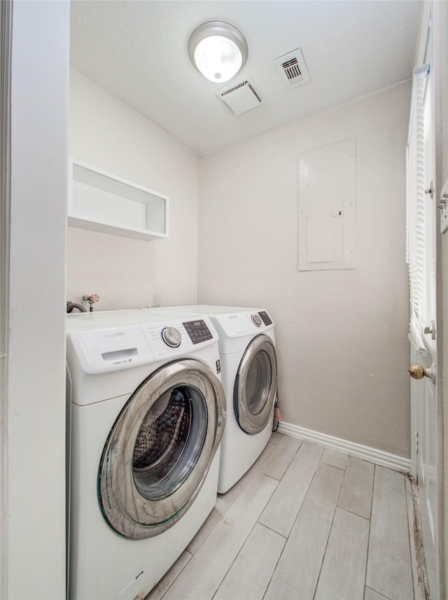 laundry room with laundry area, visible vents, baseboards, washer and dryer, and wood finish floors