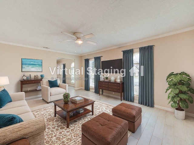 living area featuring crown molding, a wealth of natural light, a ceiling fan, and baseboards