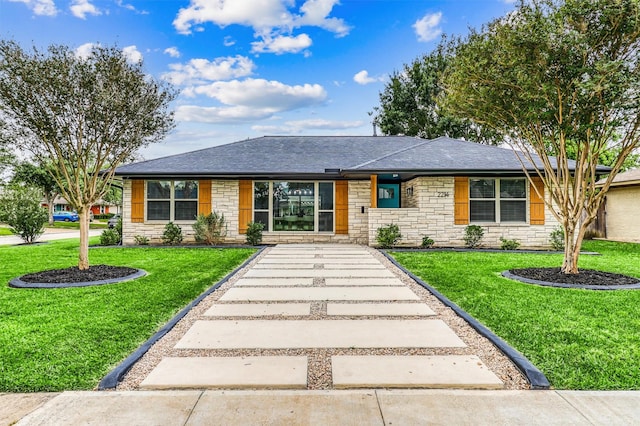 single story home with a shingled roof, stone siding, and a front lawn