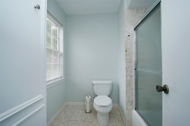 full bathroom featuring toilet, baseboards, tile patterned flooring, and enclosed tub / shower combo
