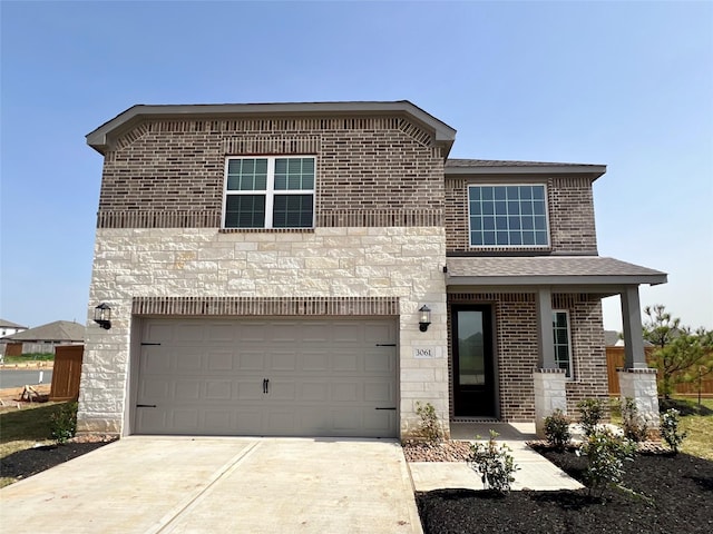 traditional home featuring stone siding, brick siding, driveway, and a garage