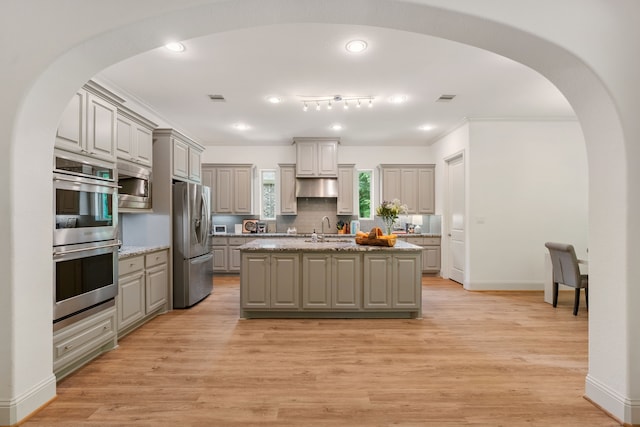 114 Pacific Grove Dr, Montgomery, TX 77316 - kitchen featuring a sink, arched walkways, gray cabinetry, and stainless steel appliances