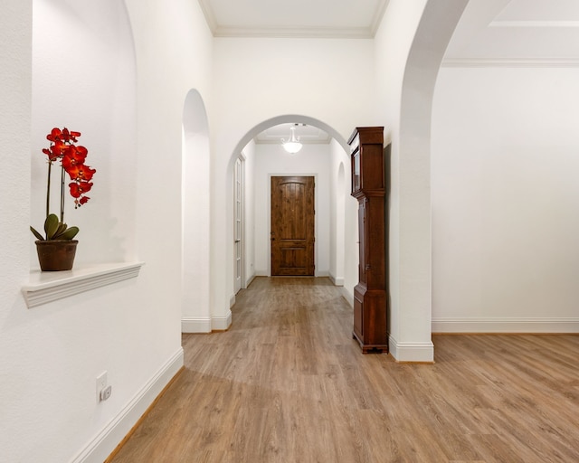 114 Pacific Grove Dr, Montgomery, TX 77316 - hallway featuring arched walkways, baseboards, ornamental molding, and light wood finished floors