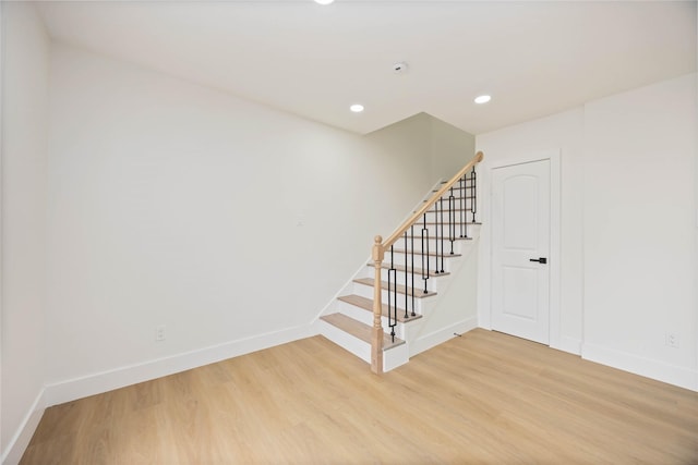 stairway featuring recessed lighting, baseboards, and wood finished floors
