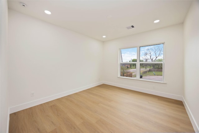 empty room featuring recessed lighting, baseboards, light wood finished floors, and visible vents
