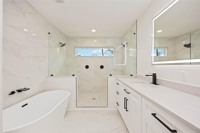 bathroom featuring marble finish floor, a freestanding bath, vanity, and a marble finish shower