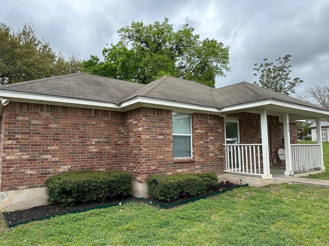 833 E Camp St, La Grange, TX 78945 - view of front of home with brick siding, a porch, and a front yard