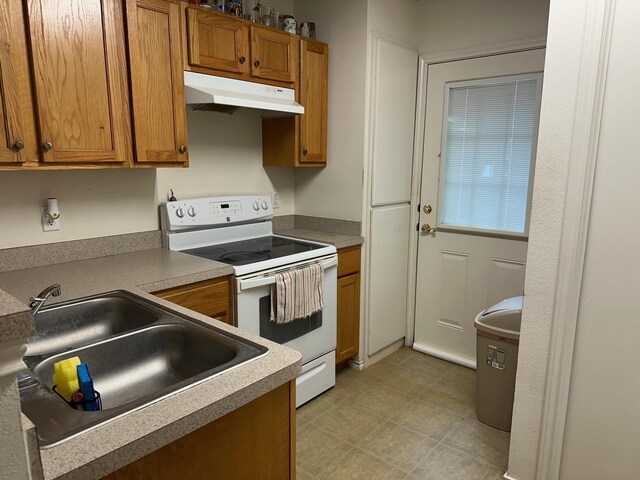 833 E Camp St, La Grange, TX 78945 - kitchen featuring under cabinet range hood, electric stove, a sink, and brown cabinets