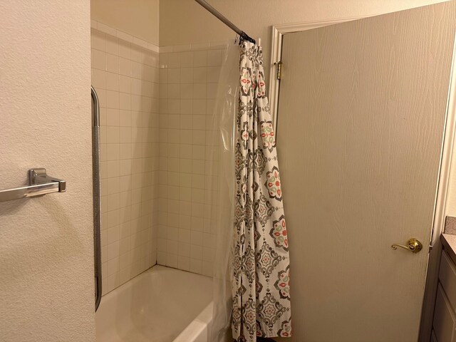 833 E Camp St, La Grange, TX 78945 - bathroom featuring vanity, shower / tub combo with curtain, and a textured wall