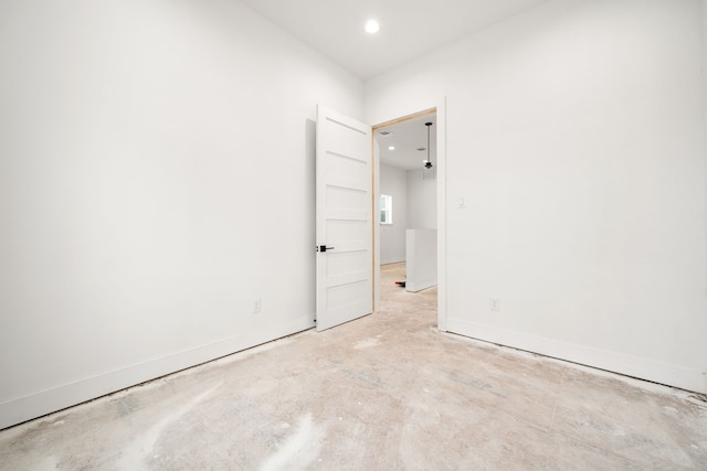 spare room featuring unfinished concrete floors and baseboards