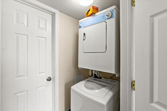 215 Postoffice St Unit 1004, Galveston, TX 77550 - laundry area with stacked washer / dryer, a textured ceiling, and laundry area