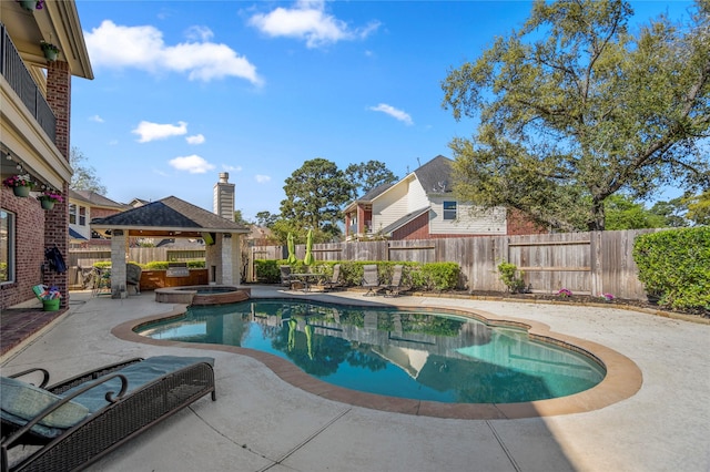 view of swimming pool featuring a gazebo, a pool with connected hot tub, a fenced backyard, and a patio area