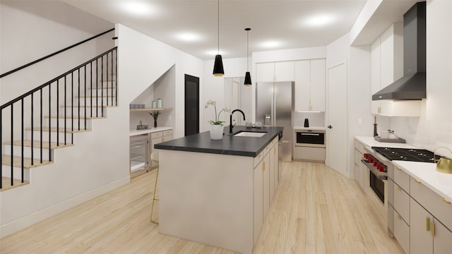1128 W Pierce St, Houston, TX 77019 - kitchen featuring a sink, wall chimney exhaust hood, light wood-type flooring, an island with sink, and tasteful backsplash