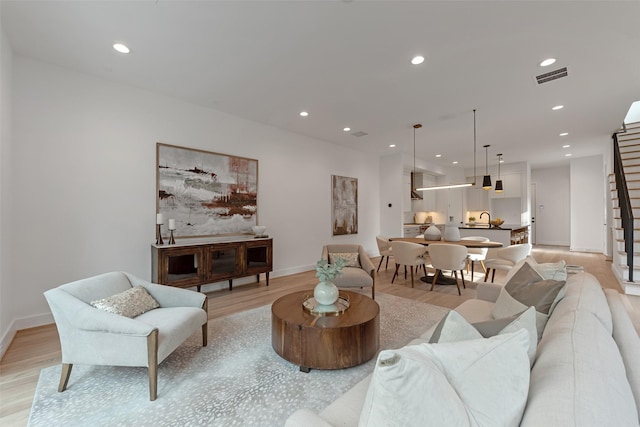 1128 W Pierce St, Houston, TX 77019 - living room with light wood-type flooring, baseboards, recessed lighting, and stairs