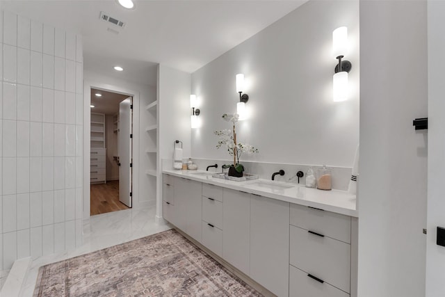 1128 W Pierce St, Houston, TX 77019 - full bath featuring marble finish flooring, double vanity, recessed lighting, a walk in closet, and built in shelves