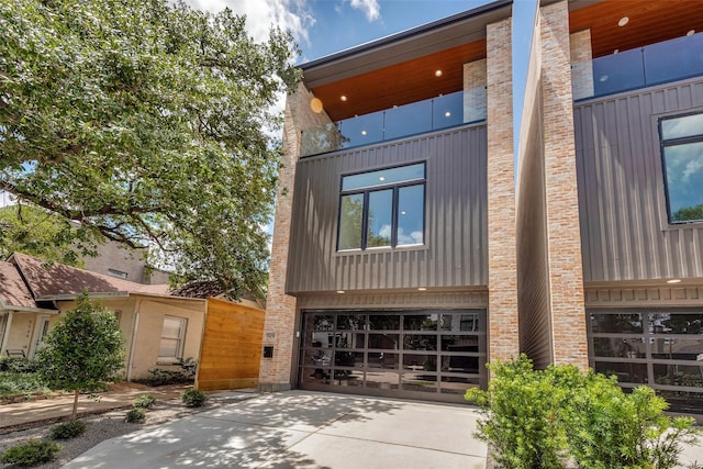 1128 W Pierce St, Houston, TX 77019 - view of front of property featuring driveway, a garage, and brick siding