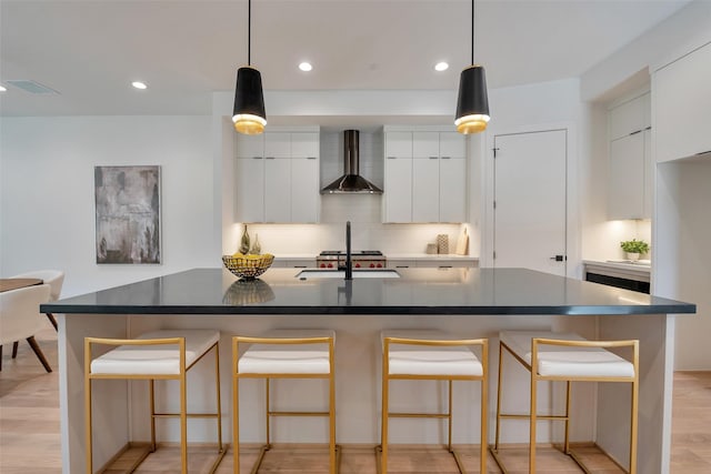 1128 W Pierce St, Houston, TX 77019 - kitchen featuring wall chimney exhaust hood, modern cabinets, decorative backsplash, dark countertops, and recessed lighting