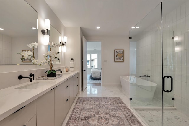 1128 W Pierce St, Houston, TX 77019 - bathroom with marble finish floors, double vanity, recessed lighting, a freestanding tub, and ensuite bathroom
