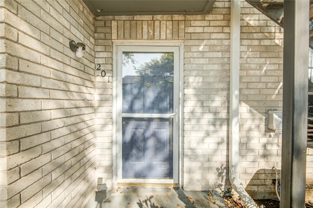 doorway to property featuring brick siding