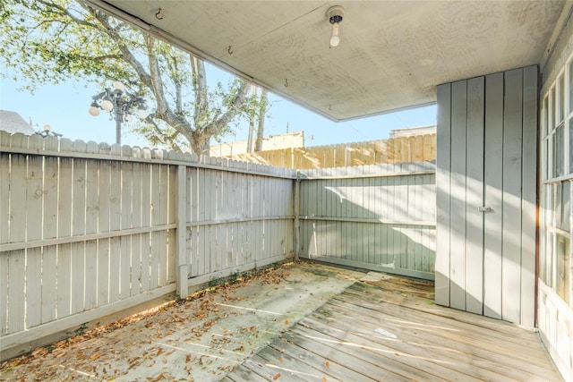 wooden deck with a fenced backyard