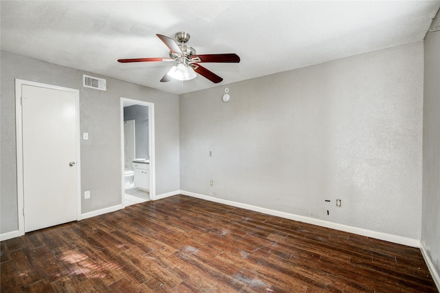 unfurnished bedroom featuring wood finished floors, ensuite bath, baseboards, and visible vents