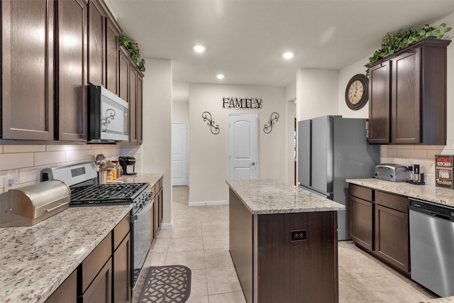 3311 Passage Ln, Conroe, TX 77301 - kitchen with stainless steel appliances, a center island, tasteful backsplash, dark brown cabinets, and recessed lighting