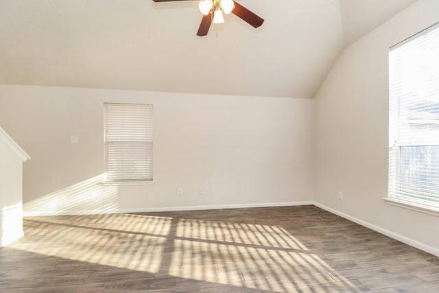 spare room featuring baseboards, vaulted ceiling, wood finished floors, and ceiling fan