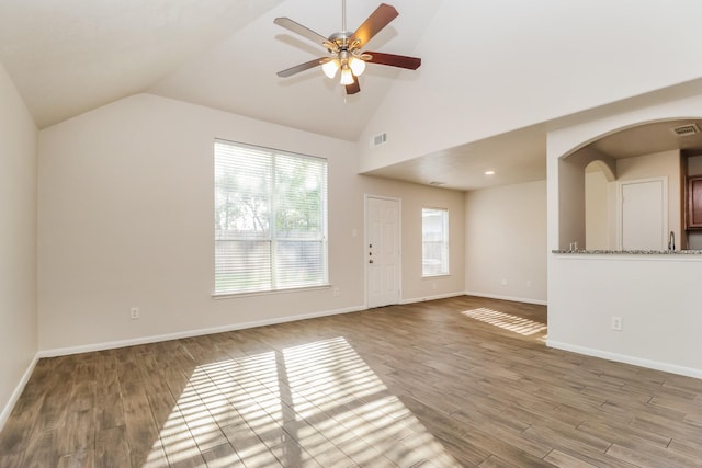 unfurnished living room featuring baseboards, visible vents, a ceiling fan, and wood finished floors