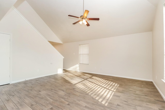interior space featuring vaulted ceiling, baseboards, ceiling fan, and light wood-type flooring