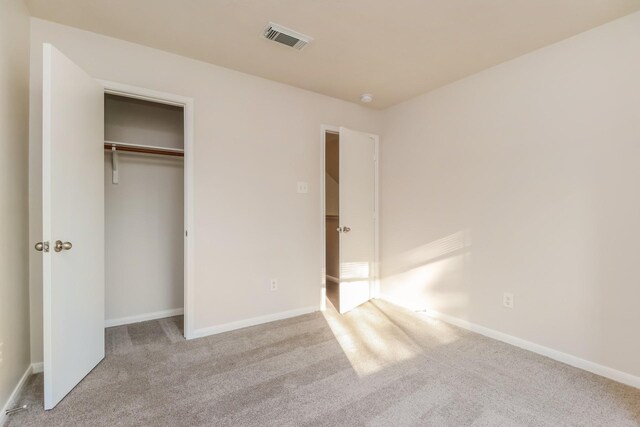 unfurnished bedroom featuring baseboards, visible vents, a closet, and carpet floors