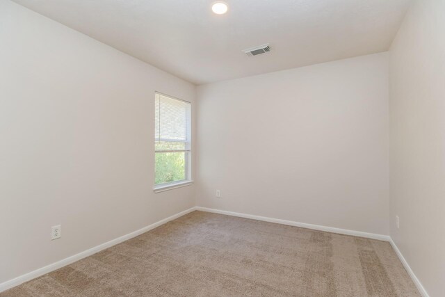empty room with light carpet, baseboards, and visible vents