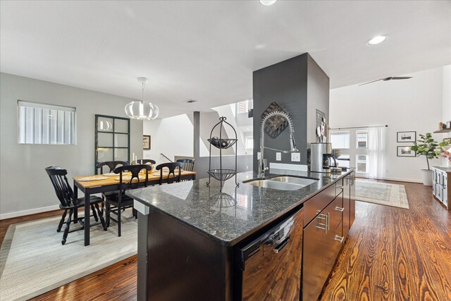 2976 Commerce St, Houston, TX 77003 - kitchen with dishwasher, a sink, dark wood-type flooring, dark stone countertops, and a kitchen island with sink