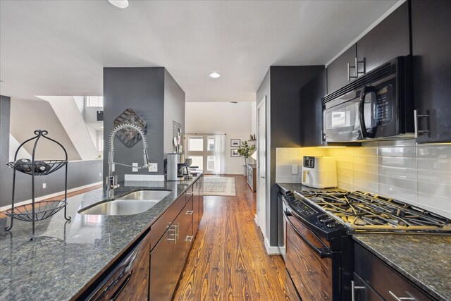 2976 Commerce St, Houston, TX 77003 - kitchen featuring black appliances, a sink, dark wood finished floors, and decorative backsplash