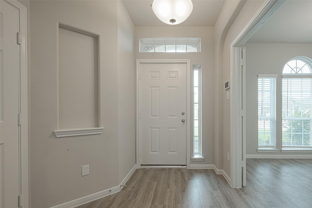 foyer entrance with baseboards and wood finished floors