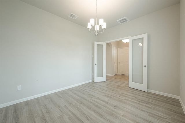 unfurnished room featuring an inviting chandelier, french doors, baseboards, light wood-style floors, and visible vents